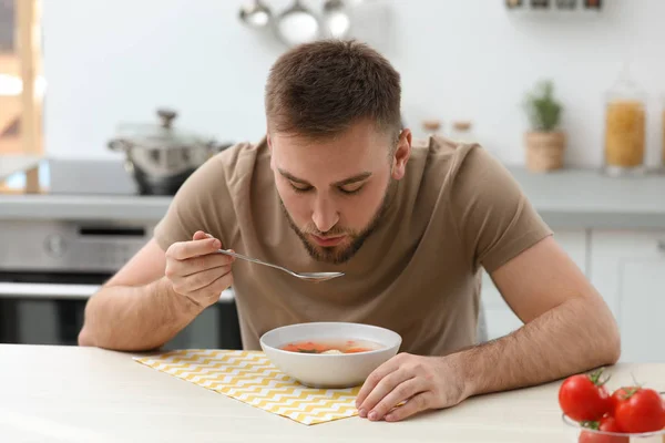 年轻人在厨房的饭桌上吃着美味的蔬菜汤 — 图库照片