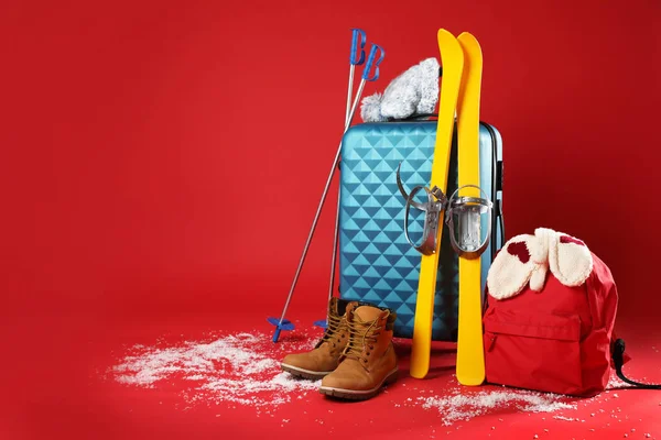 Koffer Mit Warmer Kleidung Und Skiern Auf Rotem Hintergrund Platz — Stockfoto