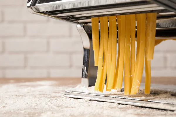Pasta maker machine with dough on table, closeup — Stock Photo, Image