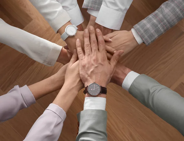 Mensen Houden Elkaars Hand Tegen Elkaar Houten Achtergrond Bovenaanzicht Eenheidsconcept — Stockfoto