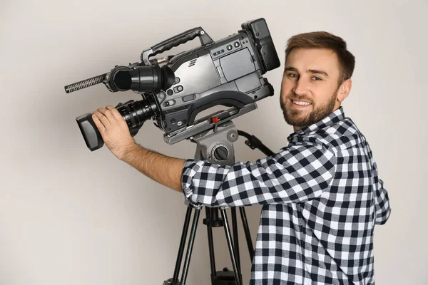 Bediener mit professioneller Videokamera auf weißem Hintergrund — Stockfoto