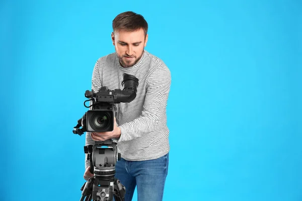 Operador com câmera de vídeo profissional em fundo azul, spac — Fotografia de Stock
