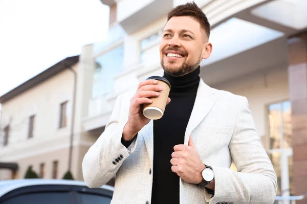 Businessman with cup of coffee on city street in morning — Stock Photo, Image