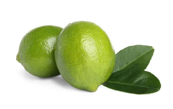 Limes freschi maturi con foglie verdi isolate su bianco — Foto Stock