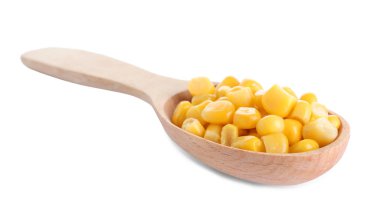 Kaşık içindeki lezzetli konserve mısır beyaza izole edilmiş.