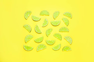 Sarı zemin üzerinde sulu taze limon dilimleri, düz uzanmış