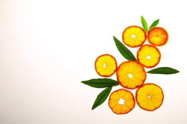 Taze taze mandalina dilimleri ve beyaz yapraklar, üst manzara. Citrus meyvesi.