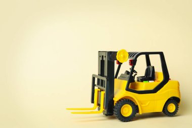 Bej arka planda oyuncak forklift, metin için boşluk. Lojistik ve toptan satış kavramı