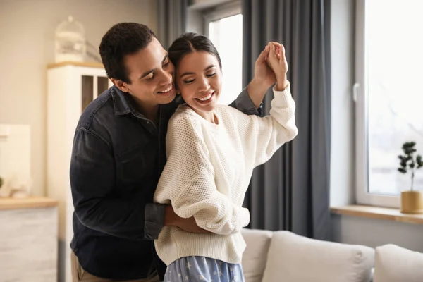 Adorável jovem casal interracial dançando em casa — Fotografia de Stock