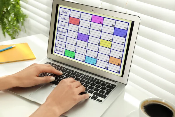 年轻女性在办公室的笔记本电脑上使用日历应用程序 特写镜头 — 图库照片