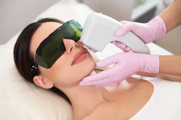 Młoda kobieta w trakcie procedury depilacji laserowej w salonie piękności — Zdjęcie stockowe