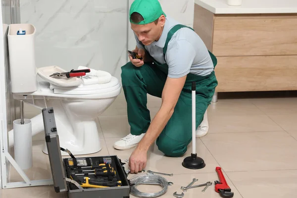 Профессиональный сантехник ремонт туалетного бака в ванной комнате — стоковое фото