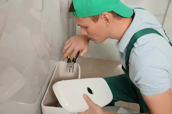 Tukang ledeng profesional memperbaiki tangki toilet di kamar mandi — Stok Foto
