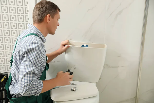 Professionell rörmokare reparera toalett skål i badrummet — Stockfoto