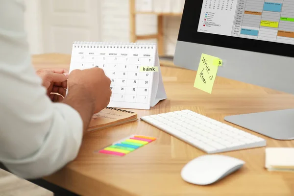 El hombre que trabaja con el calendario en la mesa en la oficina, primer plano — Foto de Stock