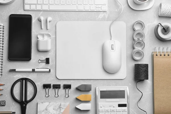 Flat lay composition with wired computer mouse and stationery on light grey table. Space for text