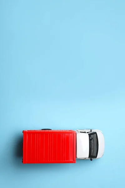 Top view of toy truck on blue background, space for text. Logistics and wholesale concept