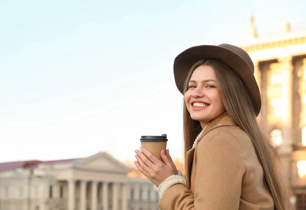 Mujer joven con taza de café en la calle de la ciudad por la mañana — Foto de Stock