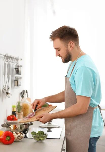 Jovem cozinhar sopa de legumes delicioso na cozinha — Fotografia de Stock