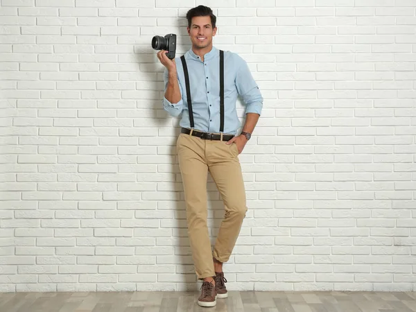 Professional photographer working near white brick wall in studi — Stock Photo, Image