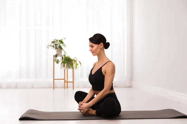 Joven acróbata profesional practicando yoga en casa — Foto de Stock