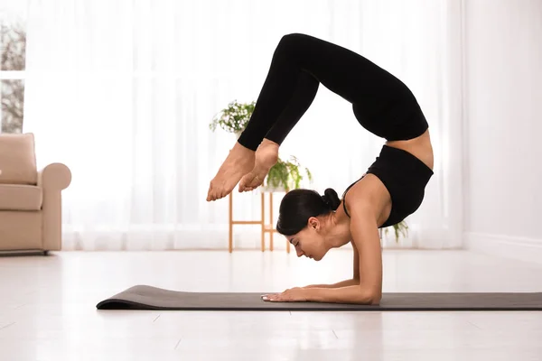 Joven acróbata profesional practicando yoga en casa — Foto de Stock