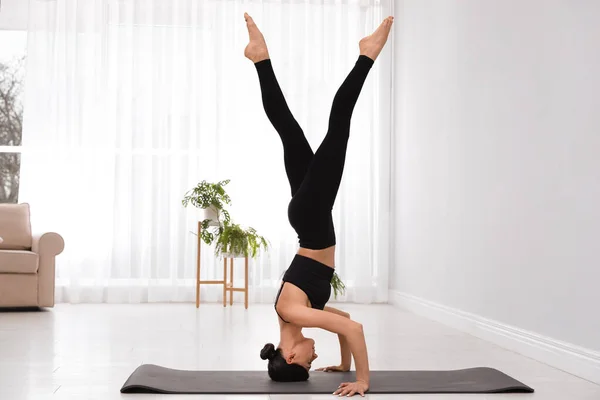 Profesjonalny młody akrobata ćwiczący jogę w domu — Zdjęcie stockowe
