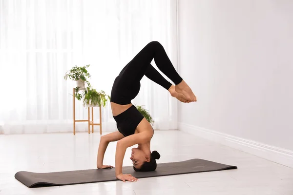 Giovane acrobata professionista che pratica yoga a casa — Foto Stock