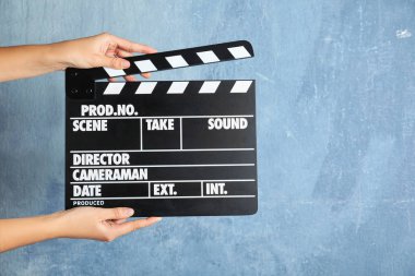 Kadın renk duvarına el çırpıyor, yazı için yeri olan bir yere yakın çekim yapıyor. Sinema yapımı