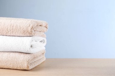 Ahşap masada temiz banyo havluları yığını. Metin için boşluk