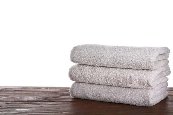 Fresh towels on wooden table against white background. Space for — Stock Photo, Image
