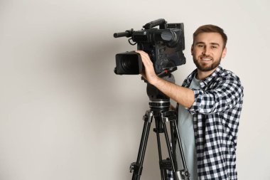 Beyaz arkaplanda profesyonel video kamerası olan operatör