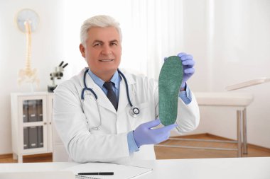 Üst düzey erkek ortopedist klinikte taban tabanı gösteriyor.