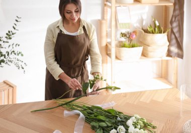 Çiçekçi atölyede güzel bir buket yapıyor.