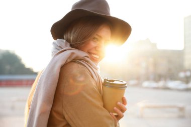 Sabahları elinde kahve olan genç bir kadın.