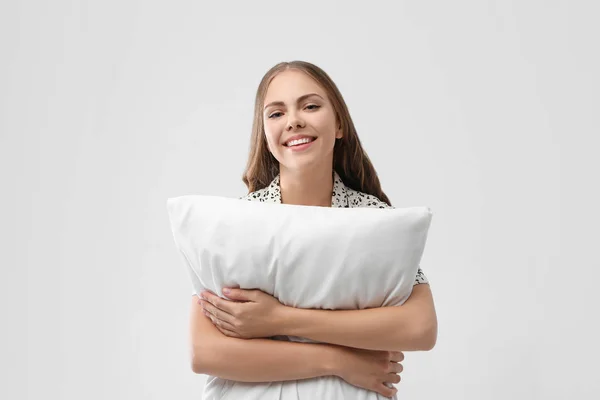 Hermosa mujer con almohada sobre fondo gris claro. Hora de dormir —  Fotos de Stock