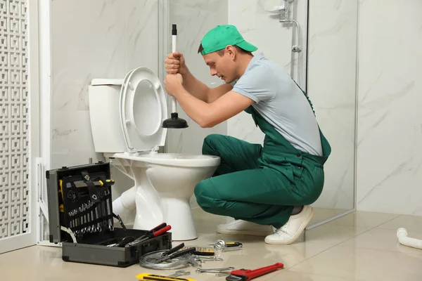 Professionele loodgieter ontstoppen afvoer van toilet kom in de badkamer — Stockfoto