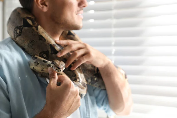 Hombre con su boa constrictor en casa, primer plano. Mascota exótica —  Fotos de Stock