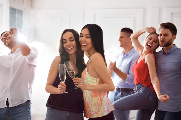 Pár šťastných přátel s tancem šampaňského na párty — Stock fotografie