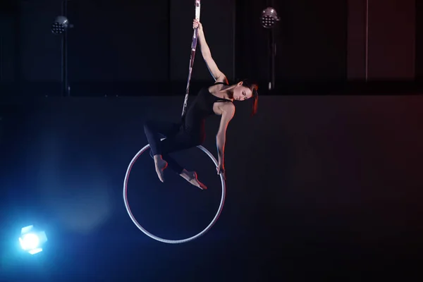 Giovane donna che esegue elemento acrobatico su anello aereo al chiuso — Foto Stock