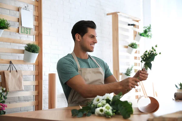 Floristería haciendo hermoso ramo en la mesa en el taller — Foto de Stock