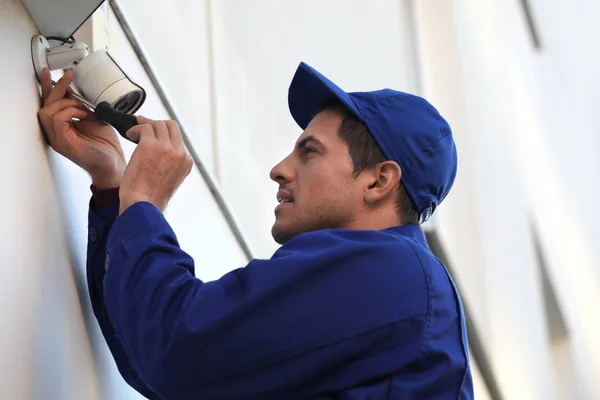 Techniker installiert Videokamera an Wand im Freien — Stockfoto