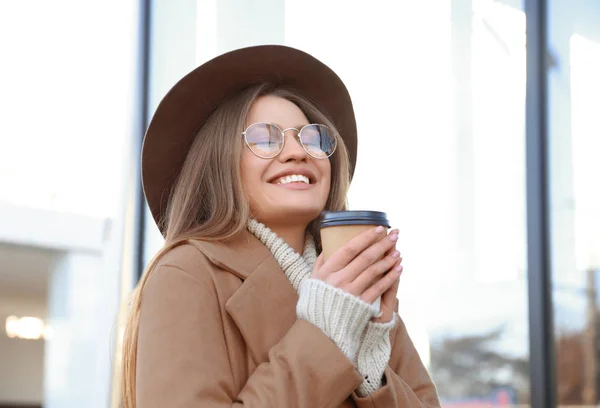 Mujer joven con taza de café en la calle de la ciudad por la mañana — Foto de Stock