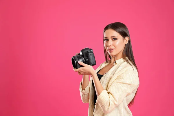 Profesionální fotograf pracující na růžovém pozadí ve studiu. — Stock fotografie