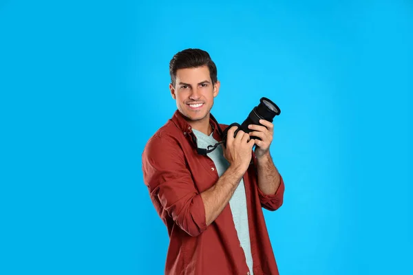 Professional photographer working on light blue background in st — Stock Photo, Image