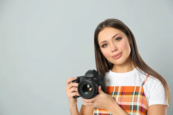 Profesionální fotograf pracující na světle šedém pozadí v st — Stock fotografie