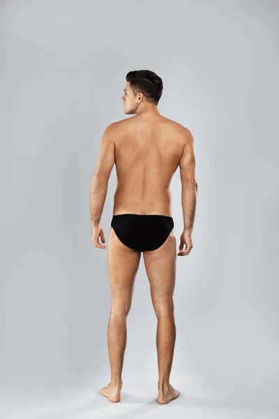 Handsome man in black underwear on light grey background, back v — ストック写真