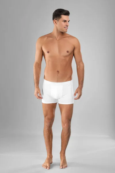 Knappe man in wit ondergoed op lichtgrijze achtergrond — Stockfoto
