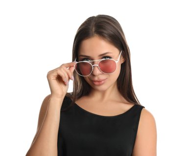 Beyaz arka planda güneş gözlüğü takan güzel genç bir kadın.