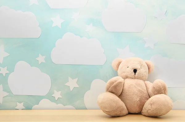 Teddybär auf weißem Holztisch neben Wand mit blauem Himmel, Raum — Stockfoto